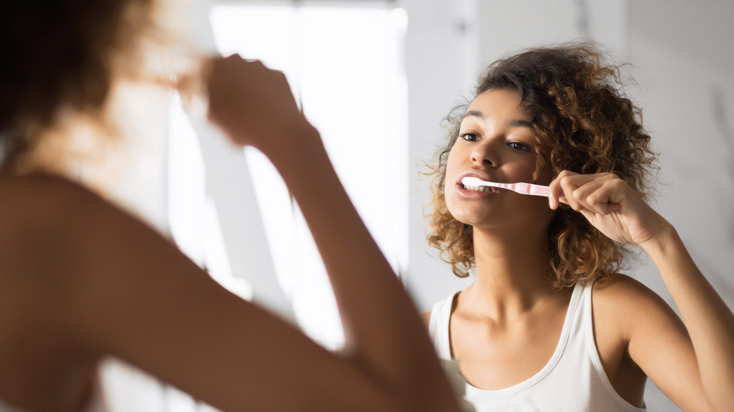 Oral Care. Young Afro Woman Brushing Teeth In Bathroom In The Morning. Panorama, Selective Focus