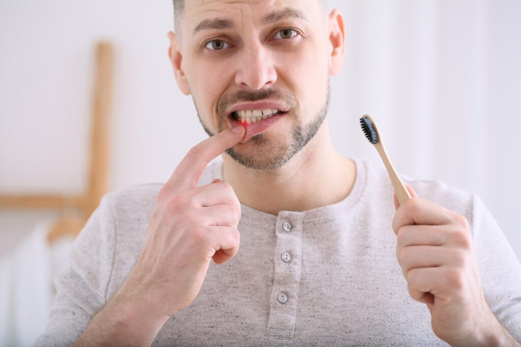 Man suffering from pain while brushing teeth in morning